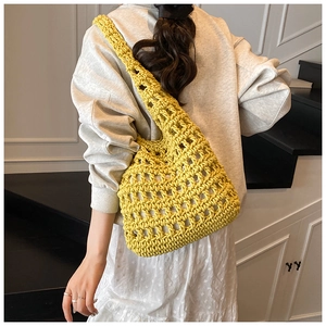 Detail of a bright yellow hollow knit tote bag showing thick mesh crochet texture