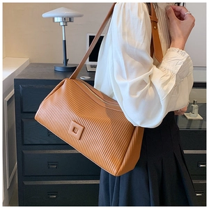 Macro detail of caramel brown pleated shoulder bag showing the unique vertical texture