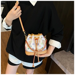 Close-up of multicolor monogram bucket bag with drawstring closure and gold hardware