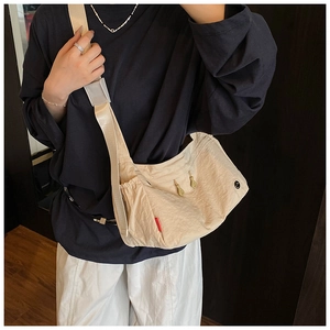 Detail of nylon crossbody bag with side drawstring pocket and red label detail