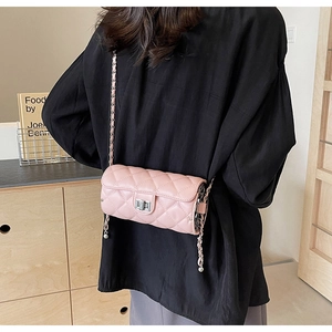 Vue détaillée du sac cylindre rose matelassé avec fermoir rotatif argenté et chaîne