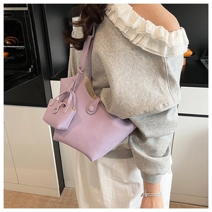 Detail of lavender bucket bag with lychee texture and matching mini pouch on shoulder