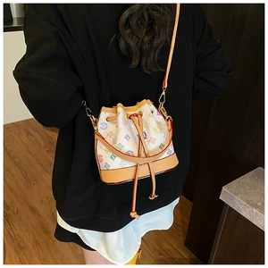 Detail of vintage bucket bag with colorful monogram print and leather drawstring