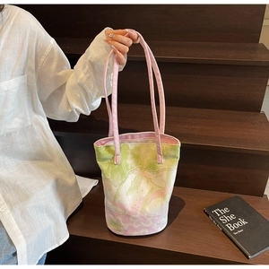 Floral canvas bucket bag with pink flower patterns held by hand against a wooden step