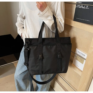 Detailed view of black large capacity tote bag with adjustable shoulder strap and buckle