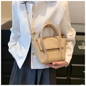 Beige PU leather crossbody bag styled with a white blazer and grey pleated skirt