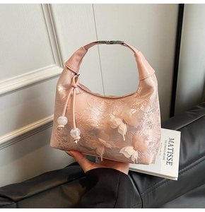 Détail du sac en satin rose avec broderie papillon 3D et perles blanches élégantes