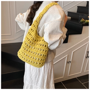 Close-up of a yellow hand-crocheted hollow tote bag with a checkered pattern texture