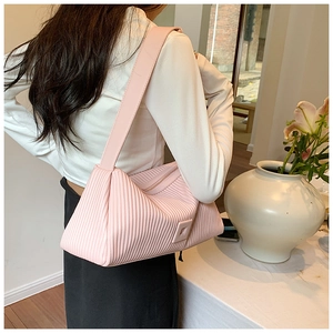 Detail of light pink pleated shoulder bag showing the vertical folds and square buckle