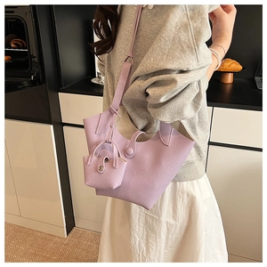 Chic purple bucket bag with matching pouch on model in a natural home setting