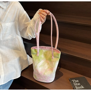 Detailed macro view of abstract floral jacquard canvas bucket bag with long pink handles