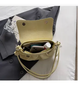 Détail de l'intérieur du sac plissé jaune montrant sa grande capacité pour cosmétiques