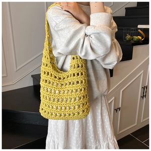 Detail of a lemon yellow hollow knit tote bag with a white inner lining and crochet texture