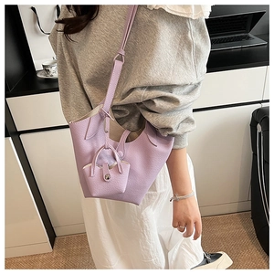 Detail of purple lychee grain leather bucket bag with matching mini charm on strap