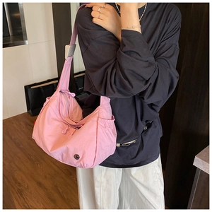 Detail of cherry pink nylon crossbody bag with drawstring side pocket and adjustable strap