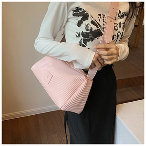 Detail of pink pleated crossbody bag with matching wide shoulder strap and square logo