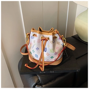Detail view of mini bucket bag featuring colorful monogram print and brown leather trim