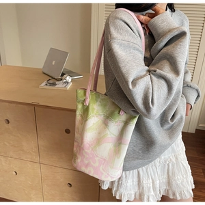 Floral canvas tote bag with pink straps worn by model in a minimalist setting