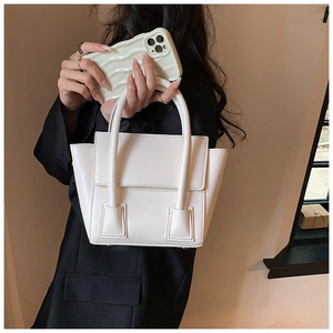 Detail showing elegant beige PU leather handbag with minimalist stitching and dual handles