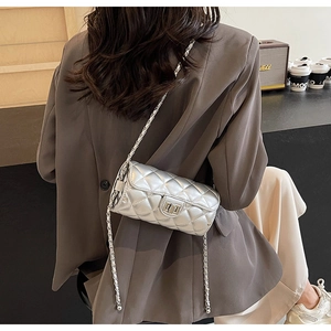 Silver quilted cylinder bag with metallic texture and sleek chain strap for women