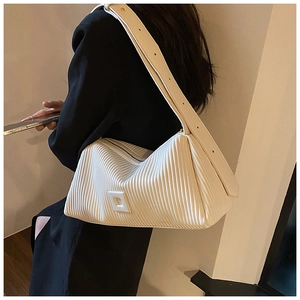 Minimalist white pleated shoulder bag with shirring texture and square buckle worn by a model