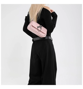 Pink punk shoulder bag featuring metal cross, hanging chains, and silver rivet details