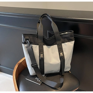 Detail of waterproof nylon tote bag showing buckled straps and durable crossbody strap