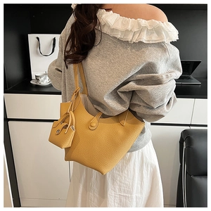 Detail view of yellow litchi pattern leather bucket bag with matching small pendant pouch