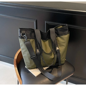 Detail view of olive green and black nylon tote bag with buckle and adjustable strap