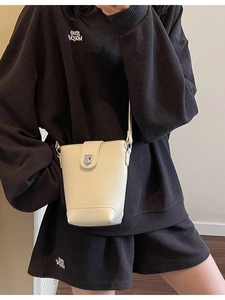 Off-white minimalist bucket shoulder bag with pebble grain leather and silver clasp