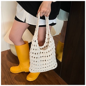 Close-up of beige crochet knit mesh tote bag with intricate rope texture and hollow design