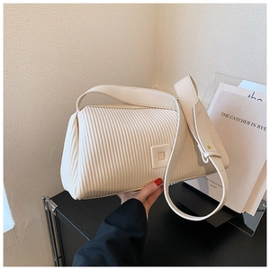 Detail of the cream pleated shoulder bag featuring a stylish vertical texture and square buckle