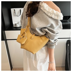 Close-up of bright yellow textured leather bucket bag with matching small inner pouch
