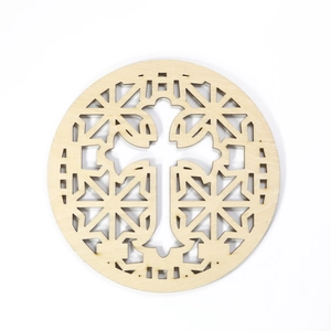 Close-up of laser-cut wooden coaster with hollow cross and geometric patterns