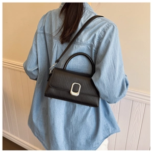 Model view of black lychee grain crossbody bag with silver buckle and adjustable strap