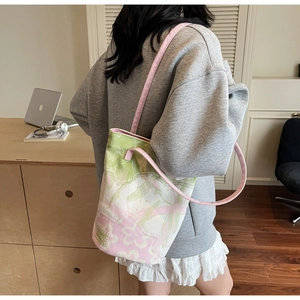 Detailed view of floral canvas tote bag with pink straps worn in a modern office setting