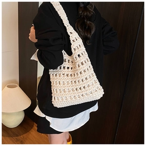 Detailed view of the white hollow crochet mesh texture and woven shoulder strap on the tote