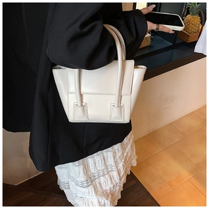 Minimalist matte white PU leather handbag styled by a model in a modern indoor setting