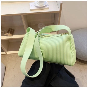 Detailed view of mint green pleated handbag with stylish accordion texture and wide strap