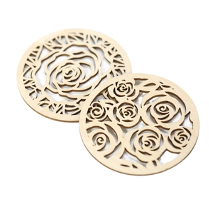 Set of two round wooden coasters with laser-cut rose hollow patterns on white background