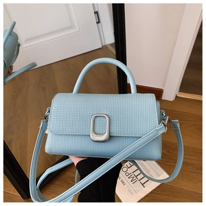 Macro shot of light blue woven texture leather bag with silver metal swivel lock detail