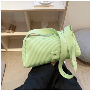 Detail of mint green pleated handbag showing vertical texture and square buckle