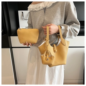 Detailed view of the yellow leather bucket bag set with matching pouch and mini charm