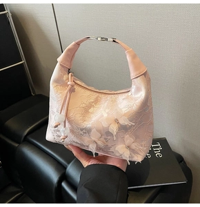 Détail d'un sac en dentelle rose avec papillons 3D et fermoir en métal argenté brillant