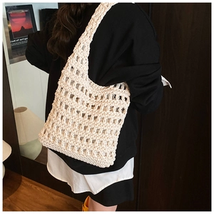 Detail of hollow knit mesh tote bag featuring a beige cotton crochet texture and hobo style