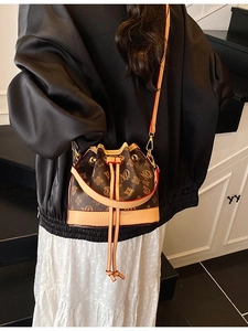 Vintage mini drawstring bucket bag with classic brown monogram pattern and beige strap