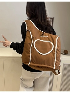 Quilted brown puffer backpack featuring white heart pattern and Fashion print