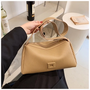 Close-up of beige pleated leather shoulder bag with square buckle and stylish strap