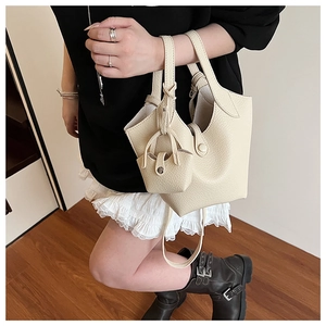 Detail of beige lychee pattern bucket bag with matching mini pouch and leather texture