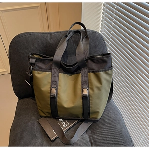 Detail of olive green nylon tote bag with dual plastic buckles and woven straps